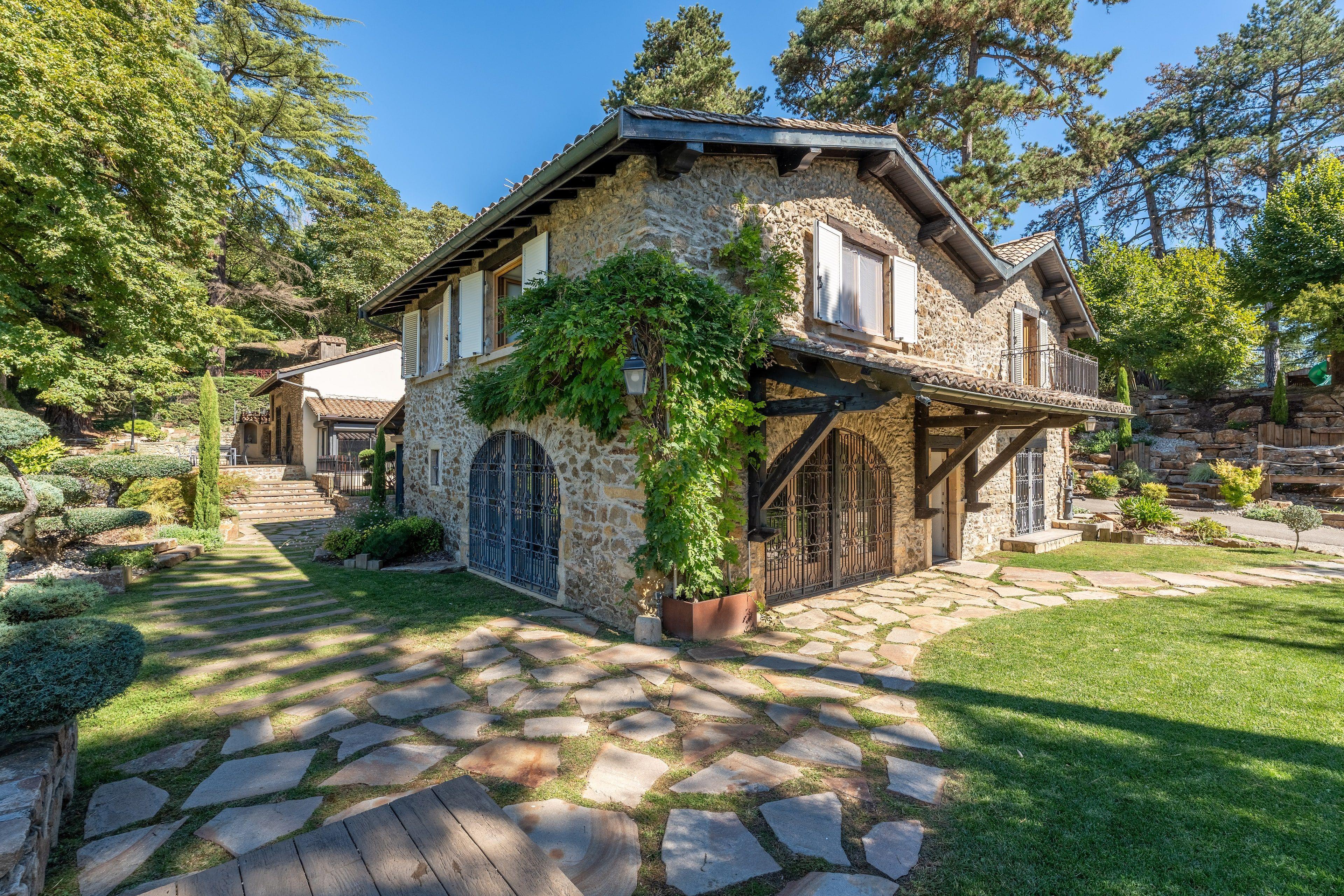 La façade en pierre de la Villa Domus sous la glycine